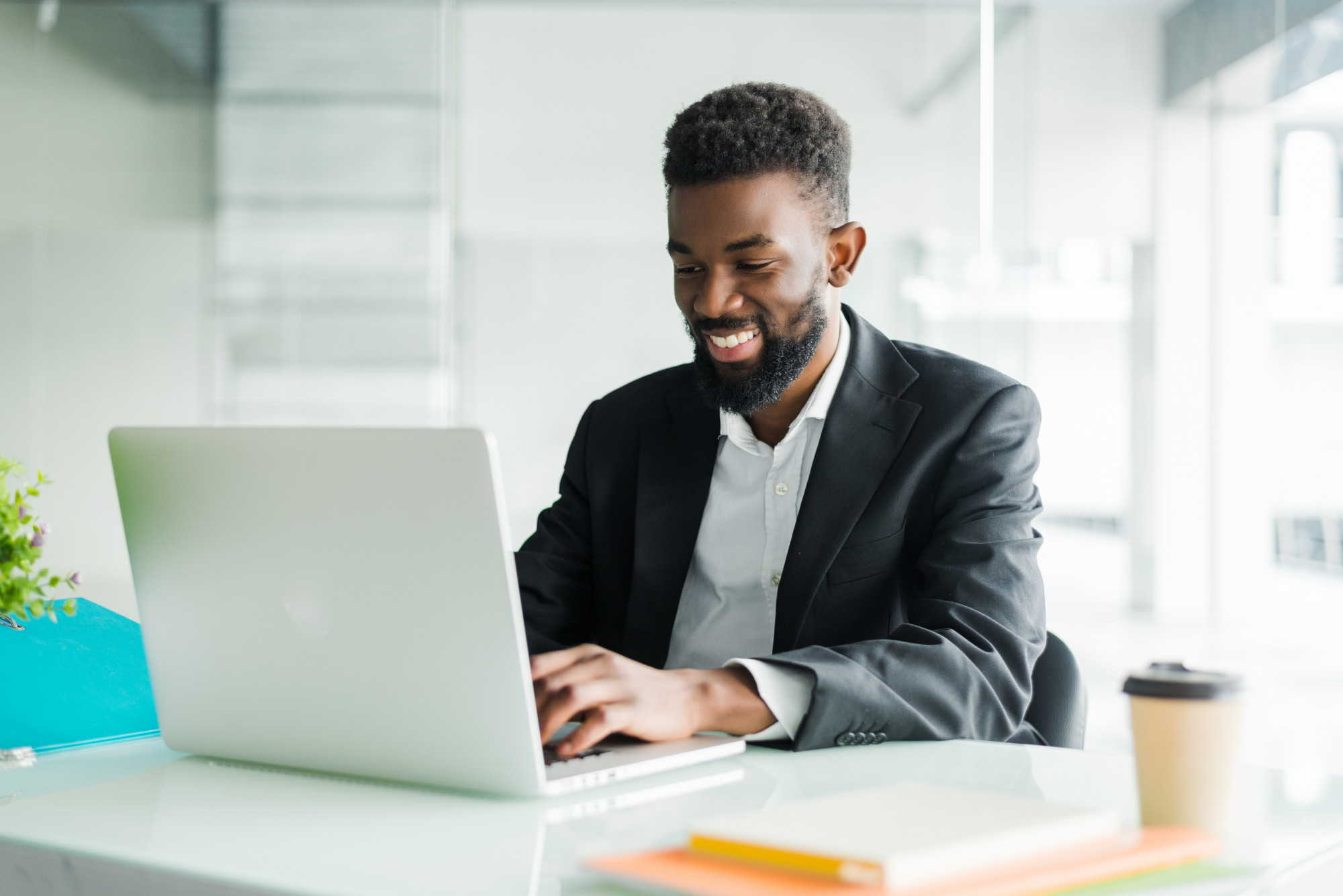 An IT Precision engineer smiling while working at his desk